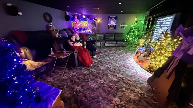Couple seated in recliners in Annville Inn's expansive movie theater, watching a show on the 75