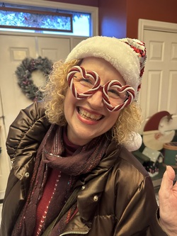Guest of Annville Inn wearing a Santa hat and Christmas themed glasses. Has a bright, big smile.