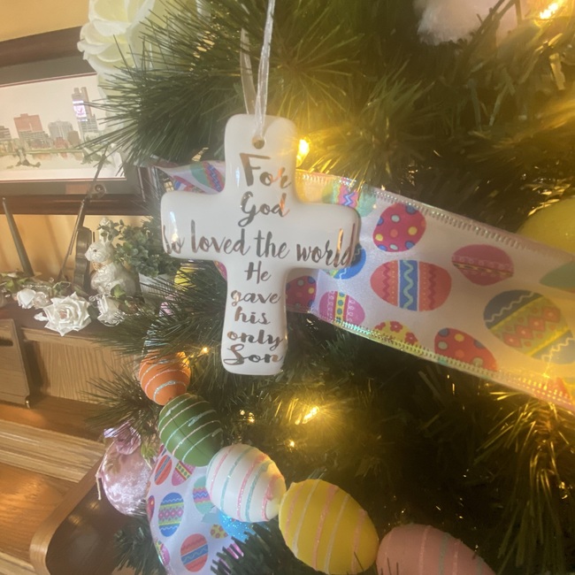Closeup photo of part of Annville Inn Easter Tree, showing a cross with a Christian message as well as secular Easter decorations.