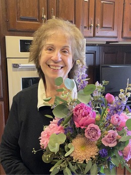 Photo of Rosalie George, Founder and Innkeeper of Annville Inn. Holding flowers from the Inn's botanical gardens.