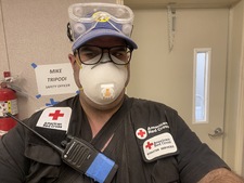 A selfie photo of Mike Tripodi wearing PPE and his Red Cross shirt