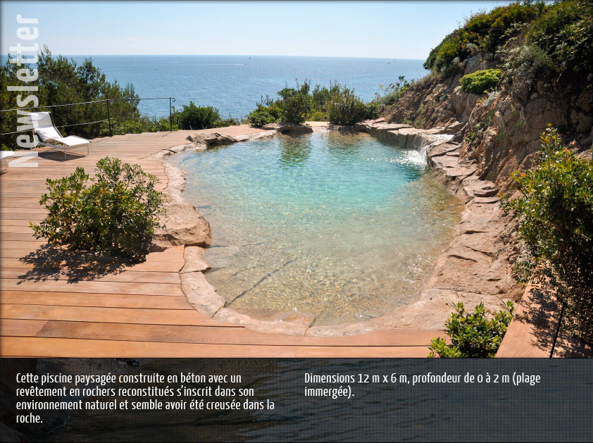 Cette piscine paysagée construite en béton avec un revêtement en rochers reconstitués s’inscrit dans son environnement naturel et semble avoir été creusée dans la roche.