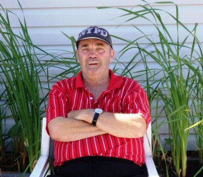 PJ, a member of one of PWDA's peer support group, sitting with his arms crossed and looking at the camera